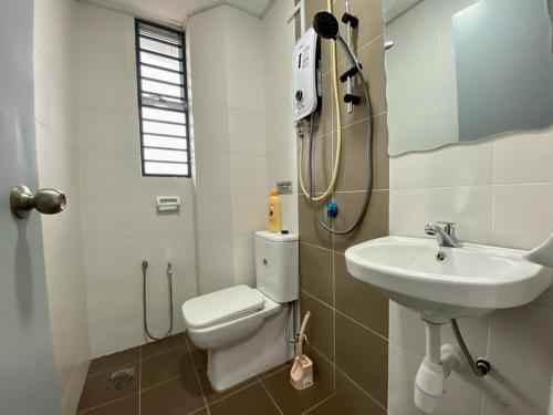 La salle de bains est pourvue de toilettes et d'un lavabo. dans l'établissement Mayura Accomodation, à Kuala Lumpur
