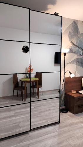 a room with a glass partition with a table at theApartments Gdańska in Łódź