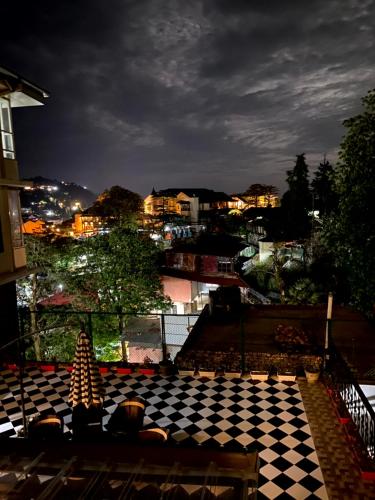 a checkered floor with a view of a city at night at Summer House in Mussoorie
