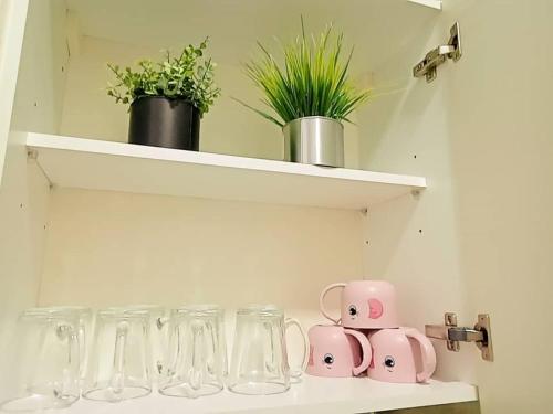 a shelf with glasses and vases on it at Legoland-4mins Walk-Spacious-Kids Friendly with Bathtub@ Happy Travel- AFINITY RESIDENCY in Nusajaya