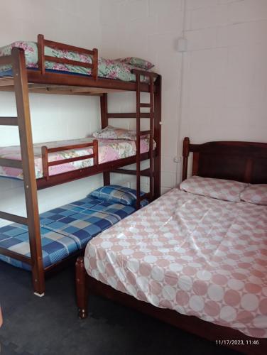 a room with two bunk beds and a bed at Recanto Monte Alegre in Praia Grande
