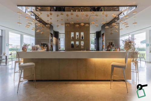 a bar in a room with chairs and a counter at HOTIDAY Room Collection - Pisa in Pisa