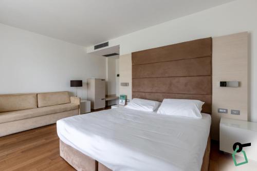 a bedroom with a large bed and a couch at HOTIDAY Room Collection - Pisa in Pisa