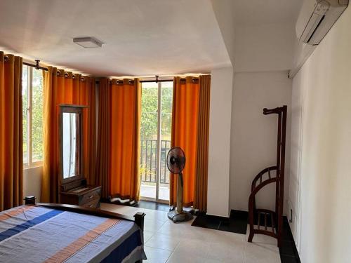a bedroom with orange curtains and a bed and a window at 2 Bedroom Apartment - Aurora Residences Maharagama in Maharagama