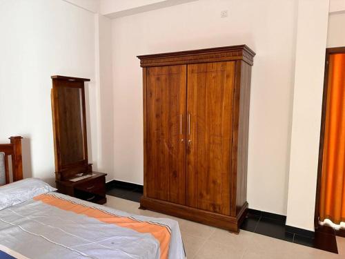 a bedroom with a wooden cabinet and a bed at 2 Bedroom Apartment - Aurora Residences Maharagama in Maharagama