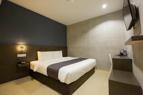 une chambre avec un lit et une télévision dans l'établissement 1 Hotel Signature, à Port Dickson
