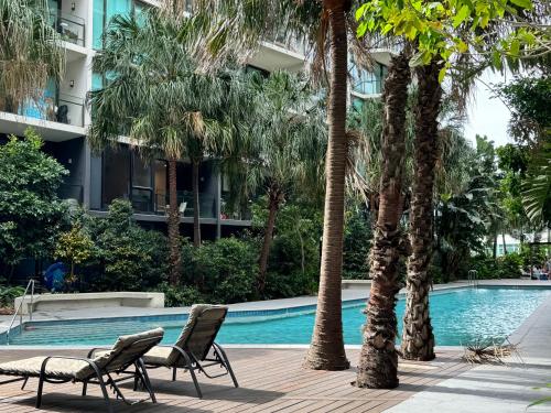 a swimming pool with two chairs and palm trees at Hidden GEM at Newstead in Brisbane