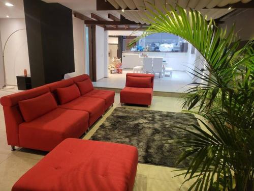a living room with a couch and two red chairs at hermosa casa en cuenca in Cuenca