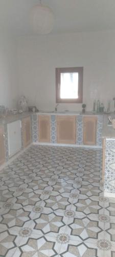 a kitchen with a tile floor and a window at Castello Bianco in Shabīkah