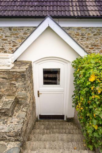 a garage with a white door and a hedge at Family Hotel Okoř in Okoř