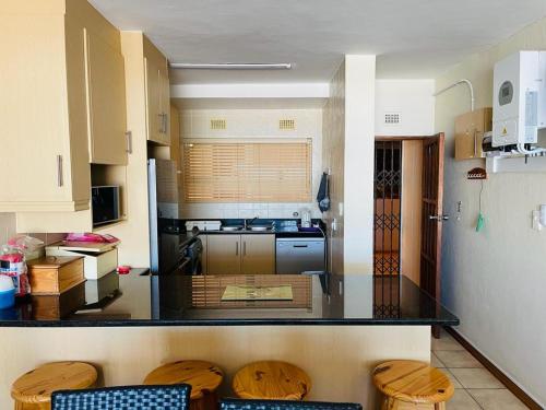 a kitchen with a counter top with wooden stools at Ramsgate Beach house in Margate