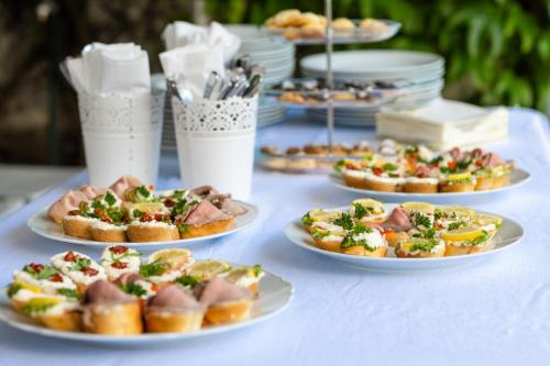 a white table with plates of food on it at Family Hotel Okoř in Okoř