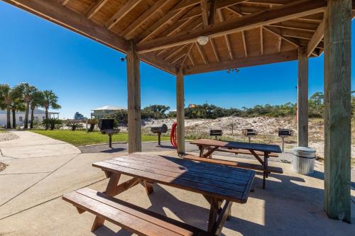 a group of picnic tables under a pavilion at The Dunes 503 condo in Gulf Shores