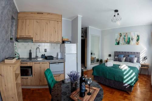 a kitchen and a living room with a bed and a table at Dream Inn apartments in Subotica
