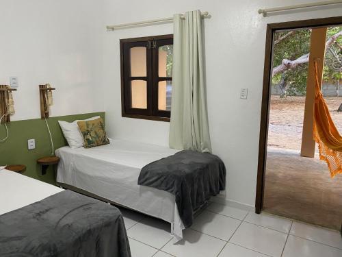 una camera da letto con un letto e una finestra di Villa Encantos do Paraíso 50mts da lagoa a Jijoca de Jericoacoara
