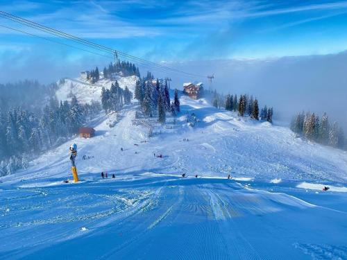 a group of people skiing down a snow covered slope at Hotel Piatra Mare in Poiana Brasov