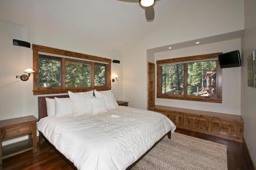 a bedroom with a white bed and two windows at North Shore Bliss by Tahoe Getaways - 3 BR plus loft & Private Hot Tub in Carnelian Bay
