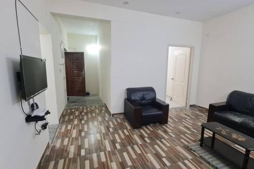 a living room with a couch and a tv at Kamalam 2 BHK - Non AC in Coimbatore