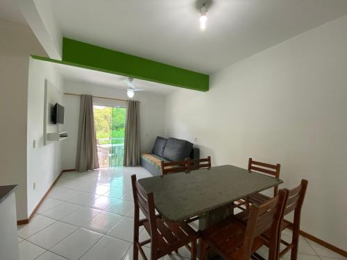 sala de estar con mesa, sillas y sofá en Residencial Recanto do Colibri, en Bombinhas