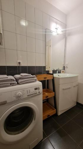una lavatrice in bagno con lavandino di Logement entier : appartement, Houssen a Houssen