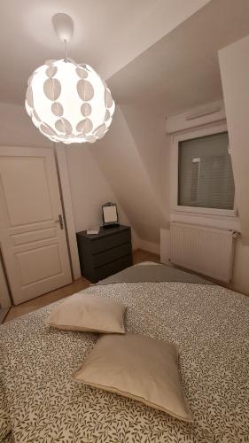 una camera con un letto e un grande lampadario di Logement entier : appartement, Houssen a Houssen