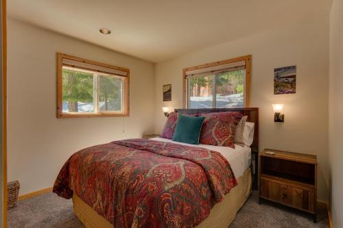 1 dormitorio con 1 cama y 2 ventanas en Piney wood - Quiet 2 BR Loft w Private Hot Tub, en Carnelian Bay