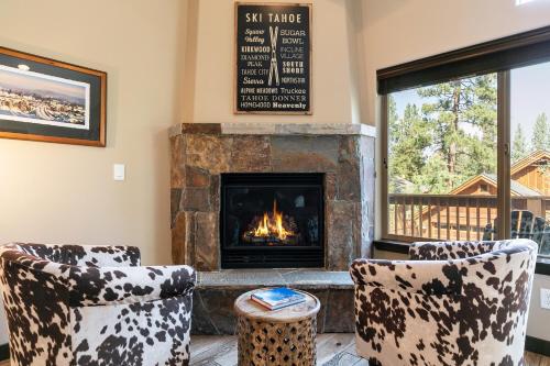 a living room with two chairs and a fireplace at Pinecrest at Winter Creek- Cozy Cabin w Hot Tub, Walk To Downtown Truckee in Truckee