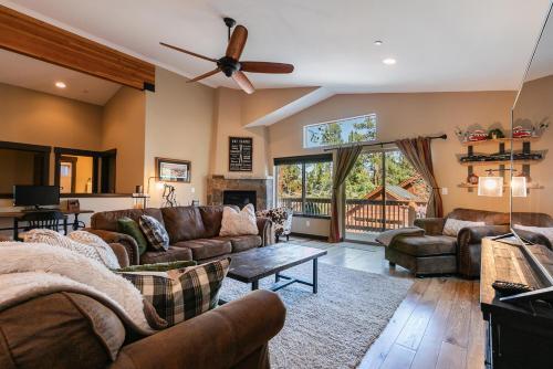 a living room with leather furniture and a ceiling fan at Pinecrest at Winter Creek- Cozy Cabin w Hot Tub, Walk To Downtown Truckee in Truckee