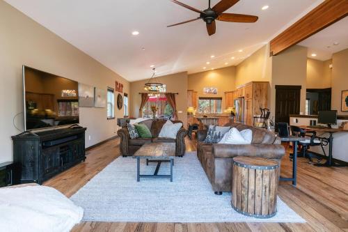 a living room with leather furniture and a ceiling fan at Pinecrest at Winter Creek- Cozy Cabin w Hot Tub, Walk To Downtown Truckee in Truckee
