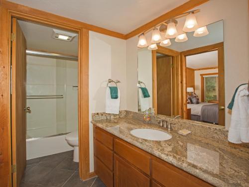 bagno con lavandino, servizi igienici e specchio di Palisades Tahoe Ski Condo - Remodeled 2 BR, Walking Distance to Lifts & Village a Olympic Valley