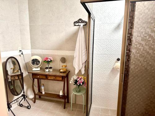 a bathroom with a shower with a table and a mirror at Freijoó Casa Vintage in Papantla de Olarte