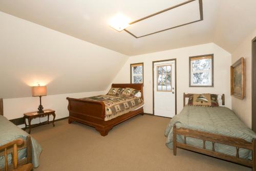 ein Schlafzimmer im Dachgeschoss mit zwei Betten und einem Fenster in der Unterkunft Pineland Chalet in Tahoe City - Classic Cabin Wood Fireplace Dog Friendly in Tahoe City