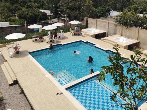 an overhead view of a swimming pool with people in it at Hotel El Don in Pueblo Bello