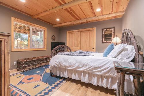 sypialnia z łóżkiem i drewnianym sufitem w obiekcie Secret Garden Lodge - 4BR Walking Distance to the Lake, Hot Tub, Close to Ski Resorts! w mieście Carnelian Bay