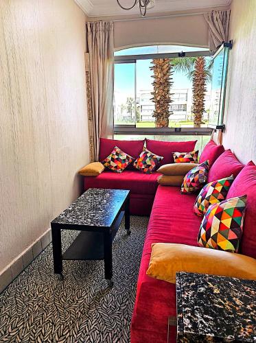 a living room with a red couch and a table at Olablanca2 in Sidi Rahal