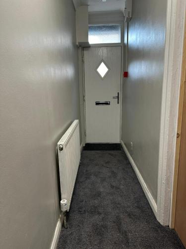 a hallway with a white door and a window at Luton Homestay - Near AIRPORT & Train Station, High Speed Internet in Luton