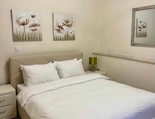 a bedroom with a bed and three pictures of flowers at Lemnos Urban Escape in Myrina