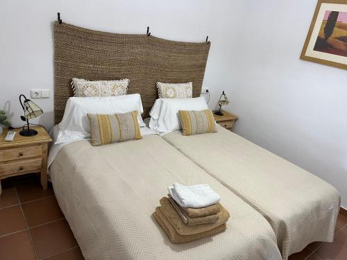 a bedroom with a large bed with towels on it at Apto. Residencial La Alcaidesa in Alcaidesa