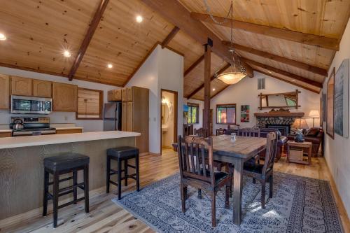 a kitchen and living room with a wooden table and chairs at Tahoe Woods by Tahoe Getaways - Pet Friendly Tahoe Park Cabin w Hot Tub, Fireplace, Near Skiing! in Tahoe City