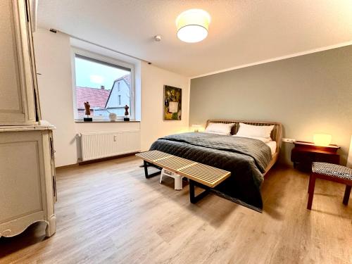 Schlafzimmer mit einem Bett, einem Fenster und einem Tisch in der Unterkunft Spatzennest 2 in Lübbecke