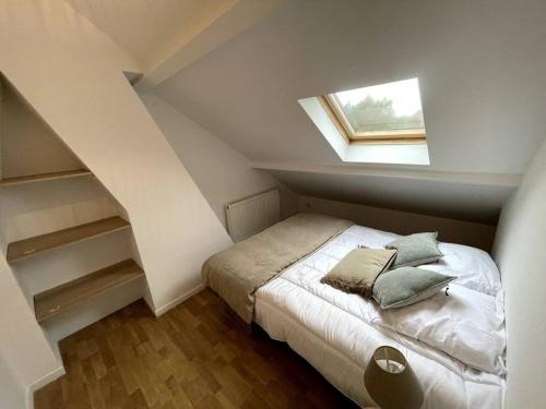 a bedroom with a bed with pillows on it at Maison de ville - près de LILLE in Mouvaux