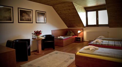 a attic room with two beds and a couch at Penzion Šejby in Horní Stropnice