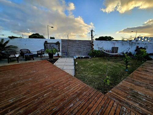 un patio trasero con una terraza de madera y una valla en AL - Studio to Travelers en Ponta Delgada