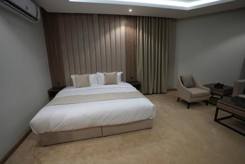 een slaapkamer met een groot wit bed en een stoel bij Awrad Royal 2 in Riyad