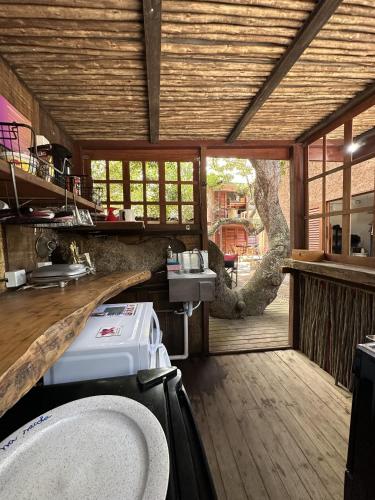 a kitchen with a sink and a counter with a window at Vulva Caraíva Hostel e Pousada para Mulheres in Caraíva