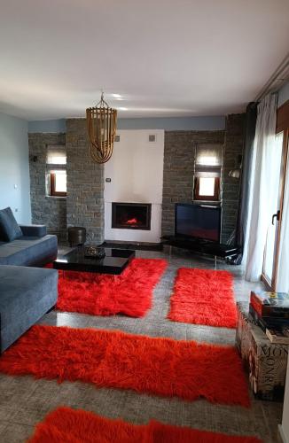 a living room with a red rug on the floor at ΑΡΧΟΝΤΙΚΟ ΜΑΝΤΕΙΟ in Manteio