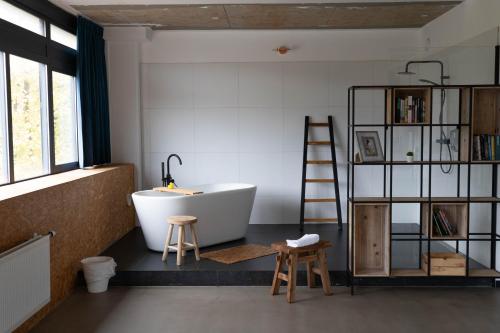 baño con una gran bañera blanca y una escalera en Urban Hotel The Golden Stork, en Rijswijk