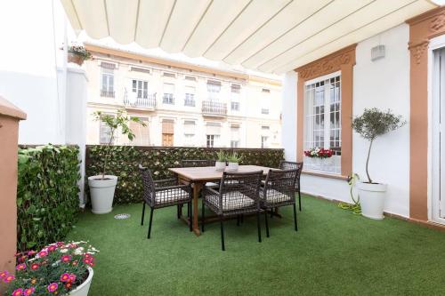 een tafel en stoelen op een patio met gras bij Family Century House with terrace and parking in Valencia