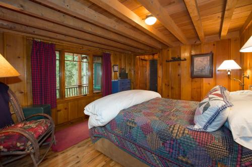 ein Schlafzimmer mit einem Bett in einer Blockhütte in der Unterkunft Ward Creek Retreat - Cozy Old Tahoe Cabin w Short Drive to Ski Resorts Pet Friendly in Tahoe City