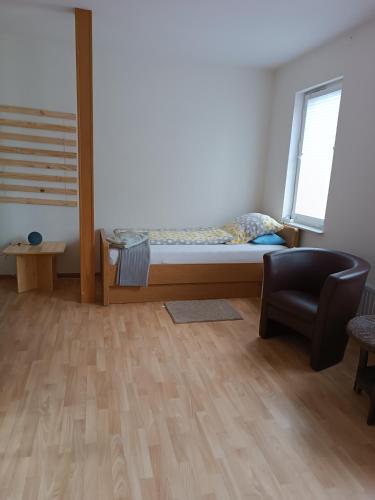 um quarto com uma cama e uma cadeira em Gästehaus Atrico Haus 7 em Neubörger